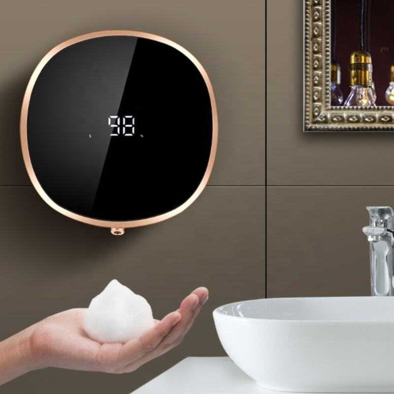 Non-contact automatic soap dispenser in bathroom, releasing foam into hand.