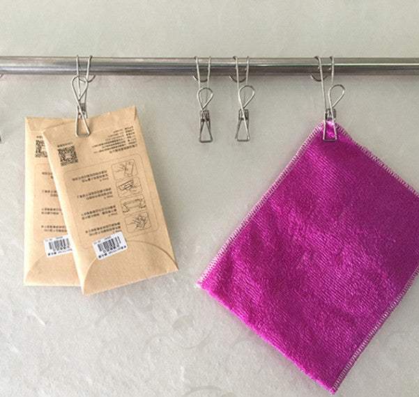 Stainless steel drying clips with hooks holding packets and a cloth on a rail.