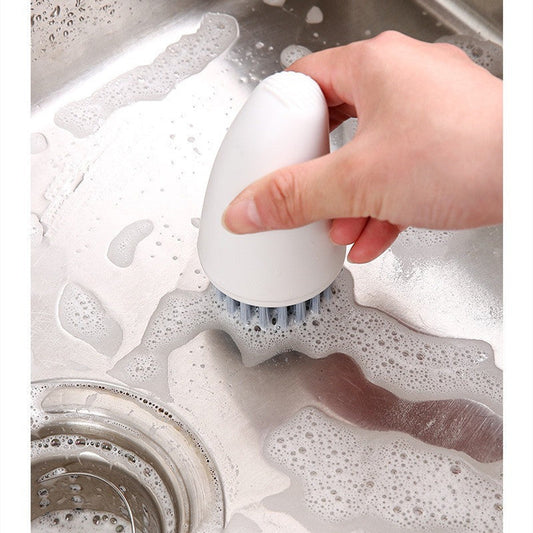 White multifunctional carrot brush cleaning a kitchen sink.